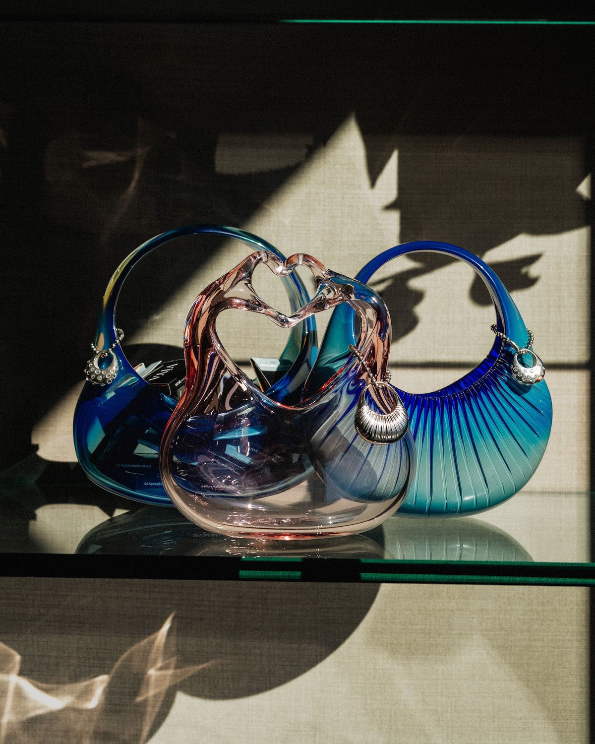 Three hand-blown glass "vases" in the shape of a handbag with mathcing silver charms/pendants with diamonds.