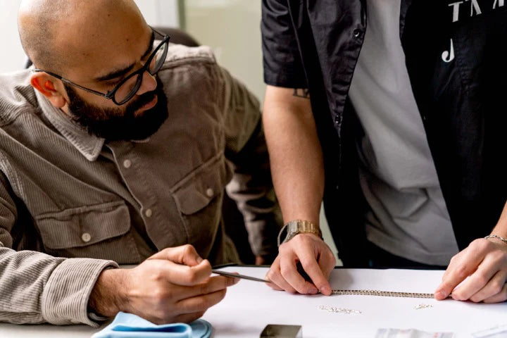 Two people working together on a project at a table.