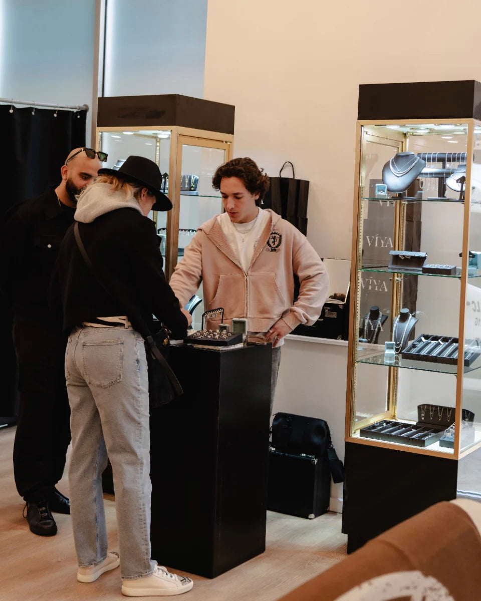 People interacting with a display case in a store setting