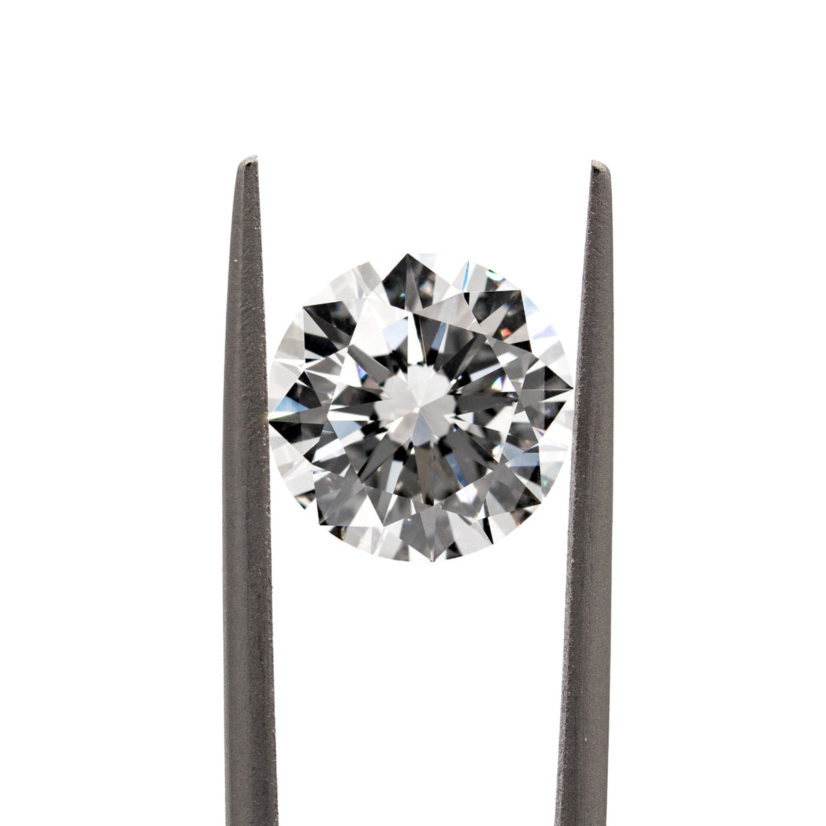 Round brilliant-cut diamond held with tweezers on a white background