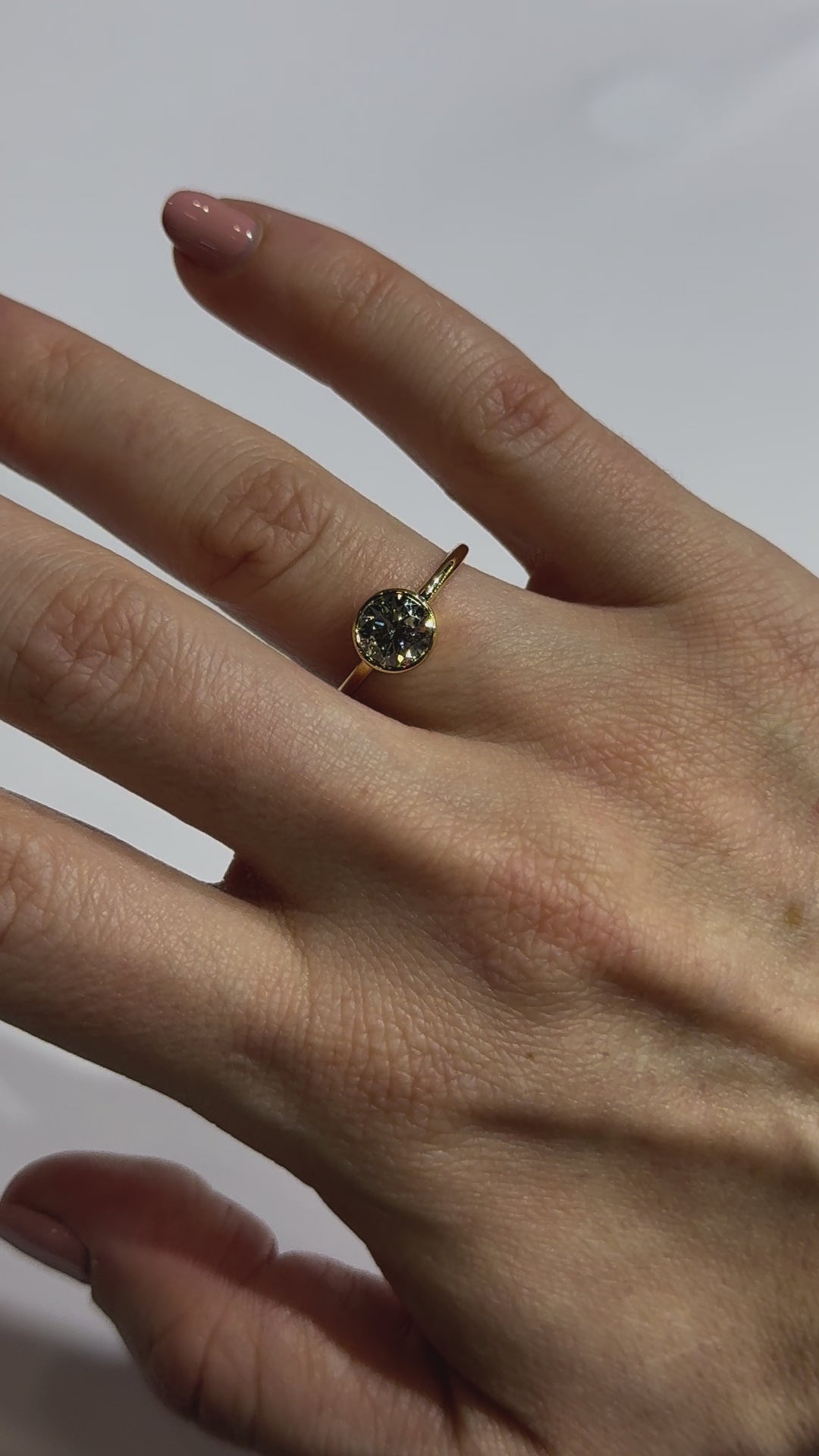 Solitaire Round Diamond Bezel Set Engagement Ring on hand